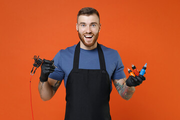 Funny professional tattooer master artist tattooed man in t-shirt apron hold machine black blue...