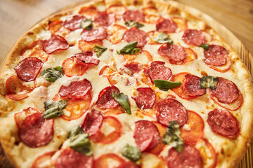 Freshly baked pepperoni pizza on wooden board