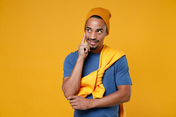 Pensive handsome young african american man 20s wearing basic casual blue t-shirt hat standing put...