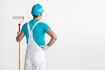 Anonymous male painter looking at wall