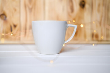 White cup on the wooden table mock up, place for a text..