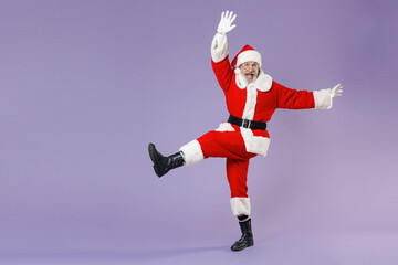 Full length portrait excited Santa Claus man in Christmas hat red suit coat glasses dancing...