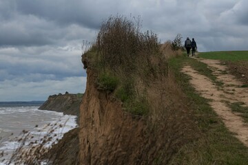 Mutter und Tochter spazieren an der Ostsee Steilküste bei Sturm