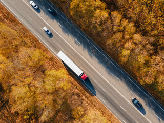 Asphalt highway or motorway road in countryside with car and truck traffic Cargo Semi Trailer Moving. Aerial Top View