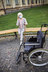 Aged woman near the nursing home making phone call