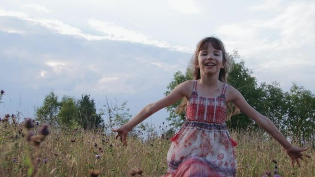 Little girl running through summer field