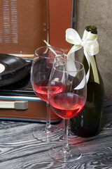 Old turntable. Nearby are two glasses and a bottle of alcohol. Retro party equipment.