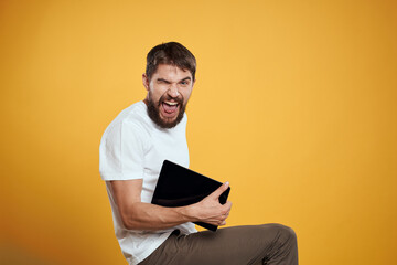 Man with a tablet on a yellow background in a white t-shirt new technologies businessman touch screen touchpad