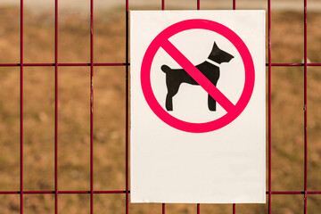 no dog walking sign on the bars, the background is blurred