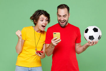 Shocked amazed young couple friends sport family woman man football fans in t-shirts cheer up...