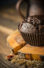 Chocolate muffin on wooden background, morning still life