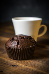 Chocolate muffin on wooden background, morning still life