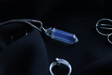 silver jewelry on a black fabric surface
