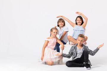 Fototapeta premium Happy young people playing together, copy space on empty white wall