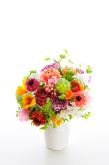 白バックに花瓶に入れた春の花のフラワーアレンジメント