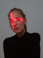 Portrait of young girl with cross shaped red light on her face