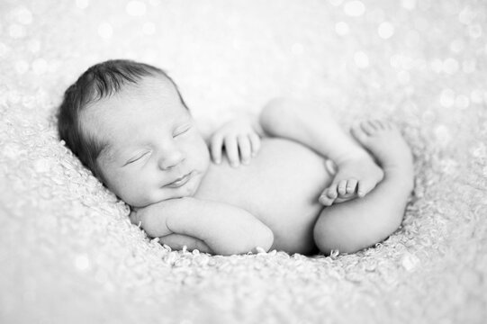 newborn baby sleeping on wool blanket. Happy baby, sleep time. Black and white picture
