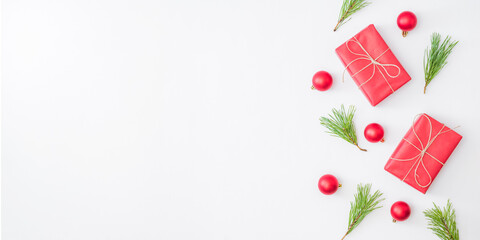 Flat lay border with red christmas decoration, pine branches on a white background
