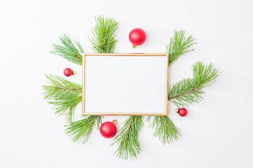Mockup gold frame with red christmas decoration, pine branches on a white background