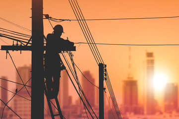Silhouette electrician on ladder is installing cable lines to connecting internet signal on...