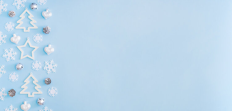 Flat lay border with christmas balls and snowflakes on a blue background - Powered by Adobe