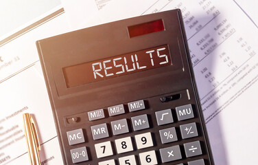 Results word on calculator on table with financial documents, flatly, top view