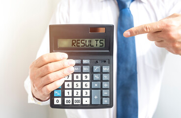 Results word on calculator in businessman hand
