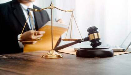 Justice and law concept.Male judge in a courtroom with the gavel, working with, computer and docking keyboard, eyeglasses, on table in morning light