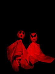 two paper ghosts for halloween with red and black lighting