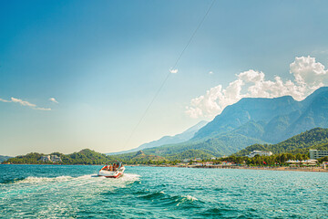 Fototapeta premium Fast boat on blue sea with mountain view, Kemer, Turkey