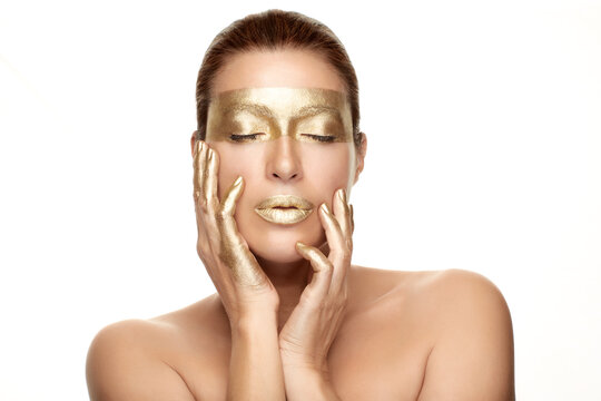 Gold based skincare concept. Beauty woman face with gold mask. Cosmetology and spa treatment