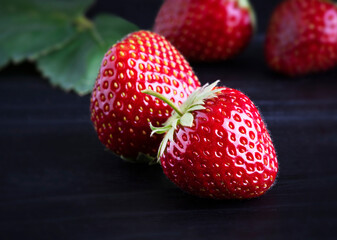 Fresh red strawberries on a dark wood background. Place for text