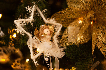 white and gold Christmas toys and doll toys hang on a Christmas tree. New Year's atmosphere. Landscape abstract map. Modern blurred postcard. Selective focus.