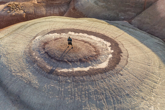 Aerial view of man standing on rock formations in Hanksville, Utah, USA.
