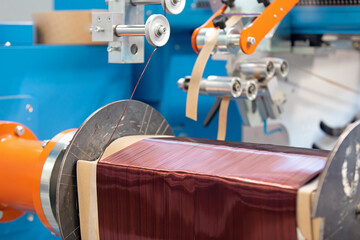 Transformer production. Round enamelled copper wire reeling to form on heavy duty coil winding machine
