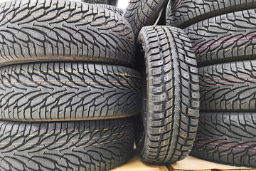 Car tires in auto store. Tires for sale in a tire store - stacks of new tires