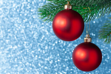 two red shiny ball on a new year tree branch on a blue blurred background, mock up.