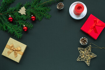 Festive Christmas background with gift boxes, fir tree, candle and baubles. Top view, copy space