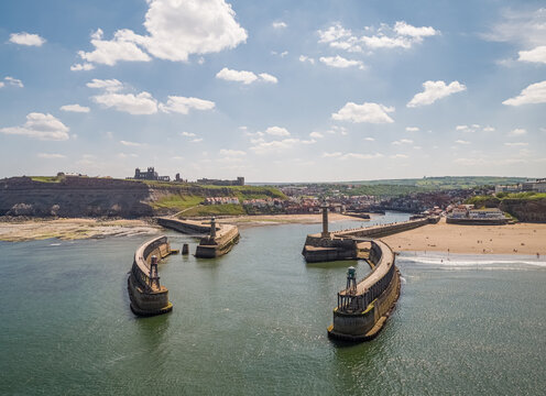 Aerial view of east and west piers each with a lighthouse and beacon, Whitby, UK.