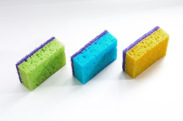 three multi-colored sponges for washing dishes on a white background.