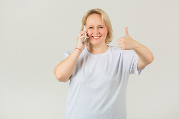 beautiful young plump female in a white t-shirt with a phone in her hand