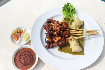 chicken satay, sate ayam and lontong with peanut sauce