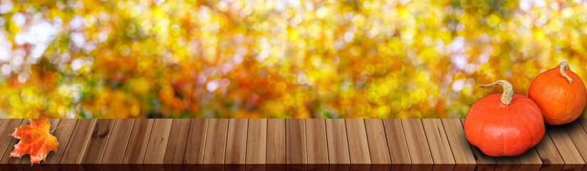 Naklejka na ściany i meble wooden table in the garden, beautiful blurred natural landscape in the background, long panorama, the concept of a cozy autumn mood, blank for the designer
