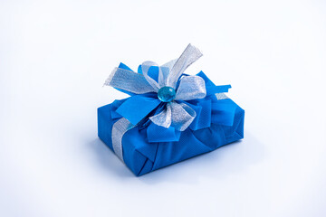 Classic blue surprise gift box with blue and white ribbon, background with copy space
