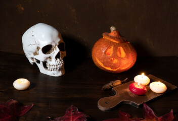 halloween. Happy halloween Carving. Halloween pumpkin head lantern on wooden background, with burning candles and human skull.