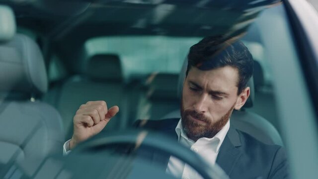 Young man sitting car in city use phone read bad news at sunlight. Feel angry stress depression. Look serious automobile. Frustrated tired. Close up. Slow motion