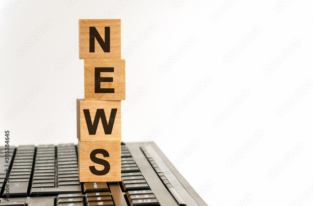 Poster concept image a wooden block and word news on white background. the cubes are located on the keyboar