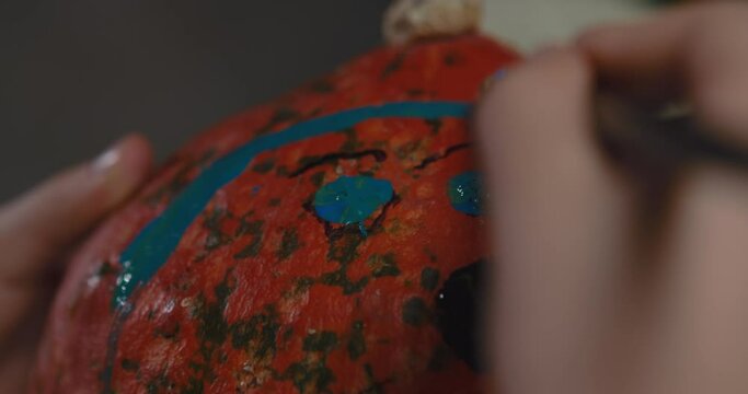 One boy decorating and painting pumpkin for halloween