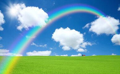 Obraz na płótnie Canvas 草原の赤い屋根の家と雲と虹と太陽