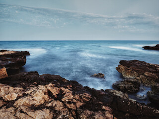 Paisaje de larga exposicion de la costa de rocas de Santa Pola del Este